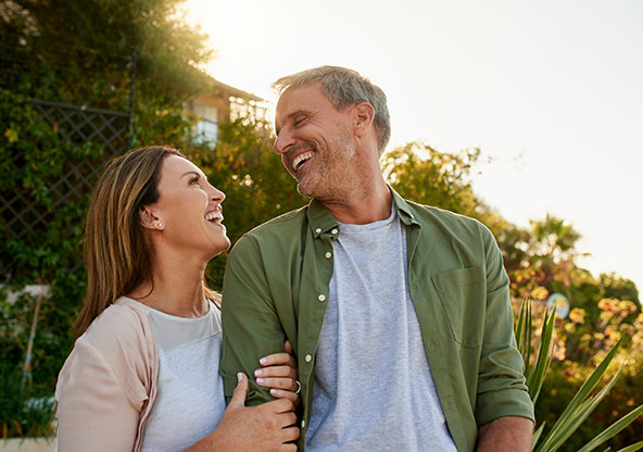 A couple in their 50s are smiling at each other