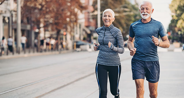 Couple of seniors jogging outdoors in the city